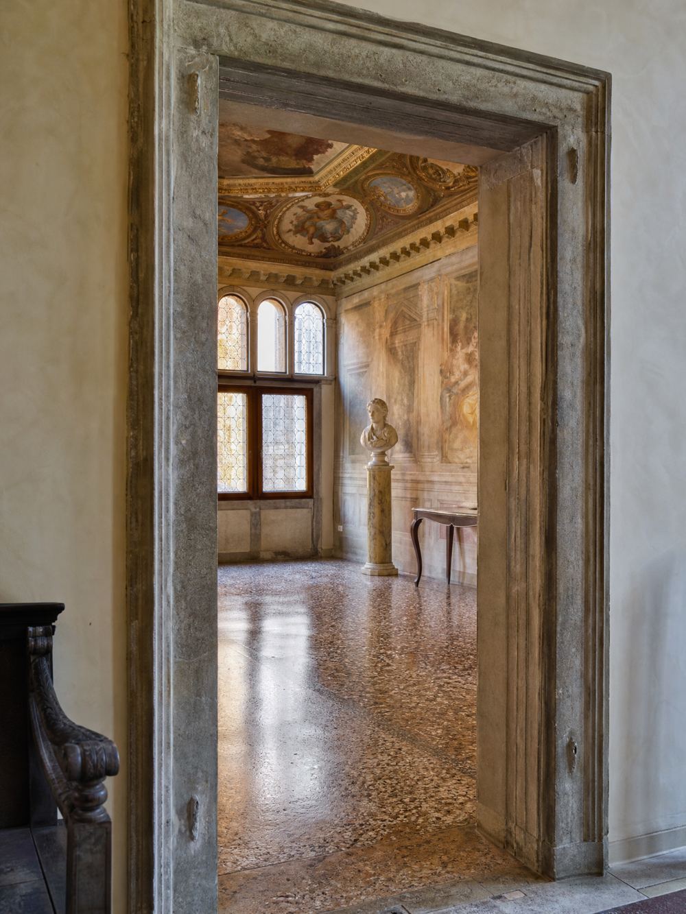 Vista attraverso un portale rinascimentale su una sala affrescata con un busto in marmo, Palazzo Grimani