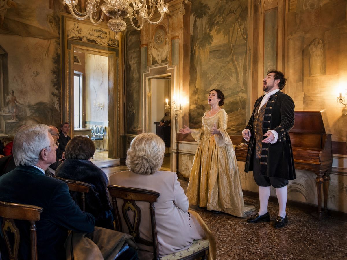 Cantanti d'opera che si esibiscono in un salone affrescato di un palazzo veneziano